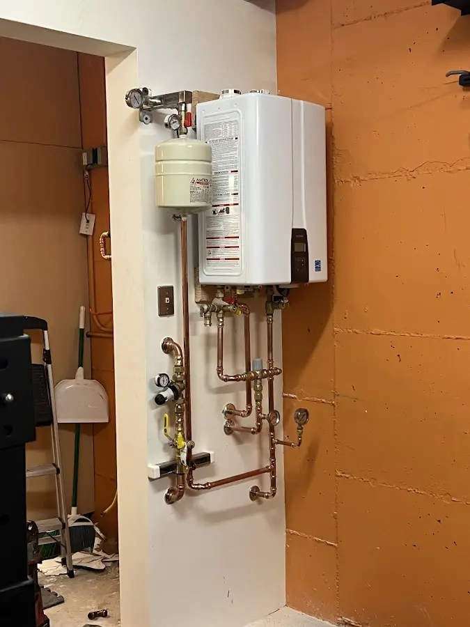 Plumbing technician inspecting water heater connections in Kankakee